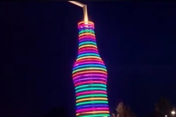 The lighted POPS bottle sculpture at night