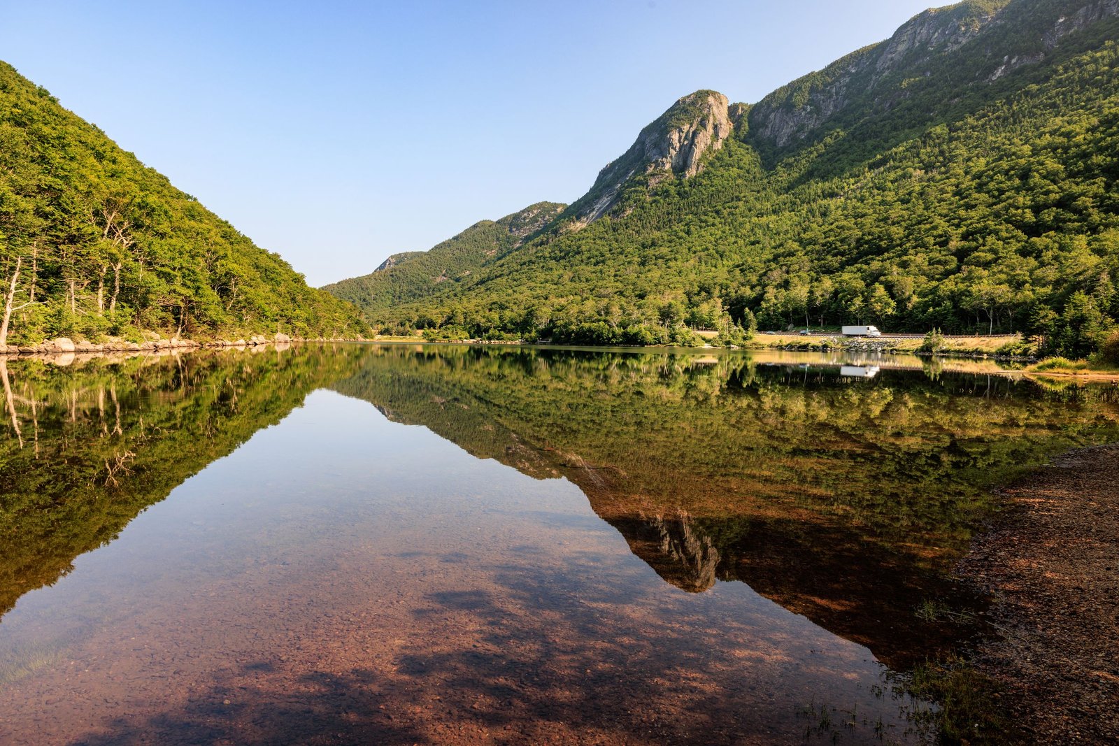 A lake reflecting wooded mountains in Franconia Notch, New Hampshire